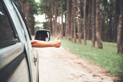 Man showing thumbs up while sitting in car