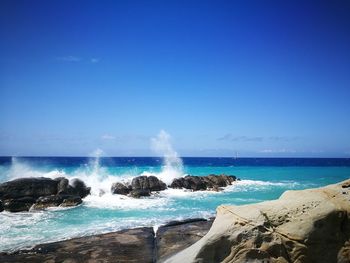 Scenic view of sea against clear blue sky