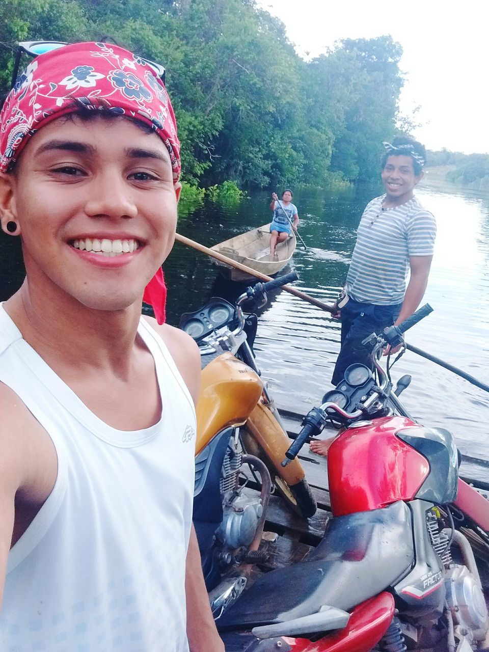 real people, casual clothing, transportation, day, smiling, outdoors, mode of transport, young adult, young women, front view, water, lifestyles, looking at camera, river, portrait, young men, sitting, oar, happiness, togetherness, nautical vessel, tree, people