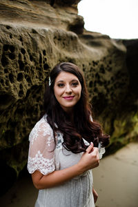 Portrait of smiling young woman standing on rock