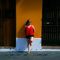 Full length of woman standing against building