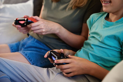 Boy and woman playing video game at home