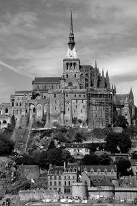 View of historical buildings in mont saint michel against cloudy sky