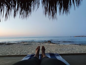 Low section of man relaxing on beach