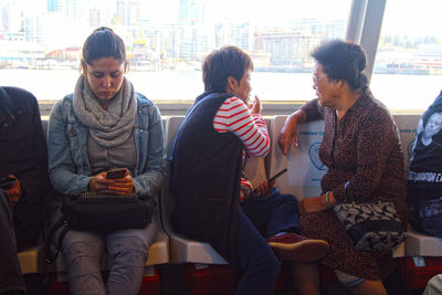 Woman sitting on mobile phone in city