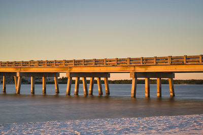 Pier over sea against clear sky