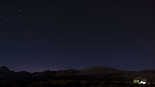 Scenic view of mountains against sky at night