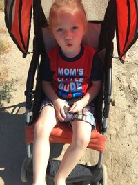 Portrait of cute boy sitting outdoors