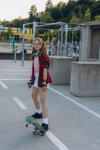 Full length of young woman standing on road