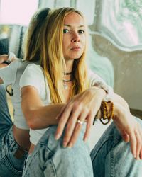 Portrait of young woman sitting on sofa at home