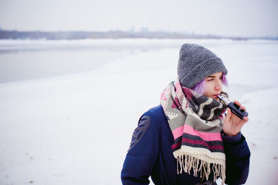 Full length of boy standing on snow covered beach