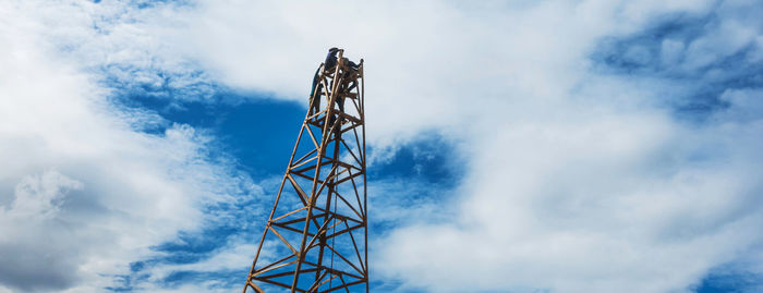 Low angle view of communications tower against sky