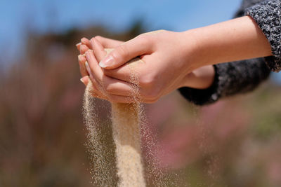 Detail shot of hands holding sand