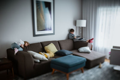 Siblings relaxing in the livingroom and doing some screentime