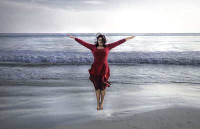 Full length of woman walking on sea shore against sky
