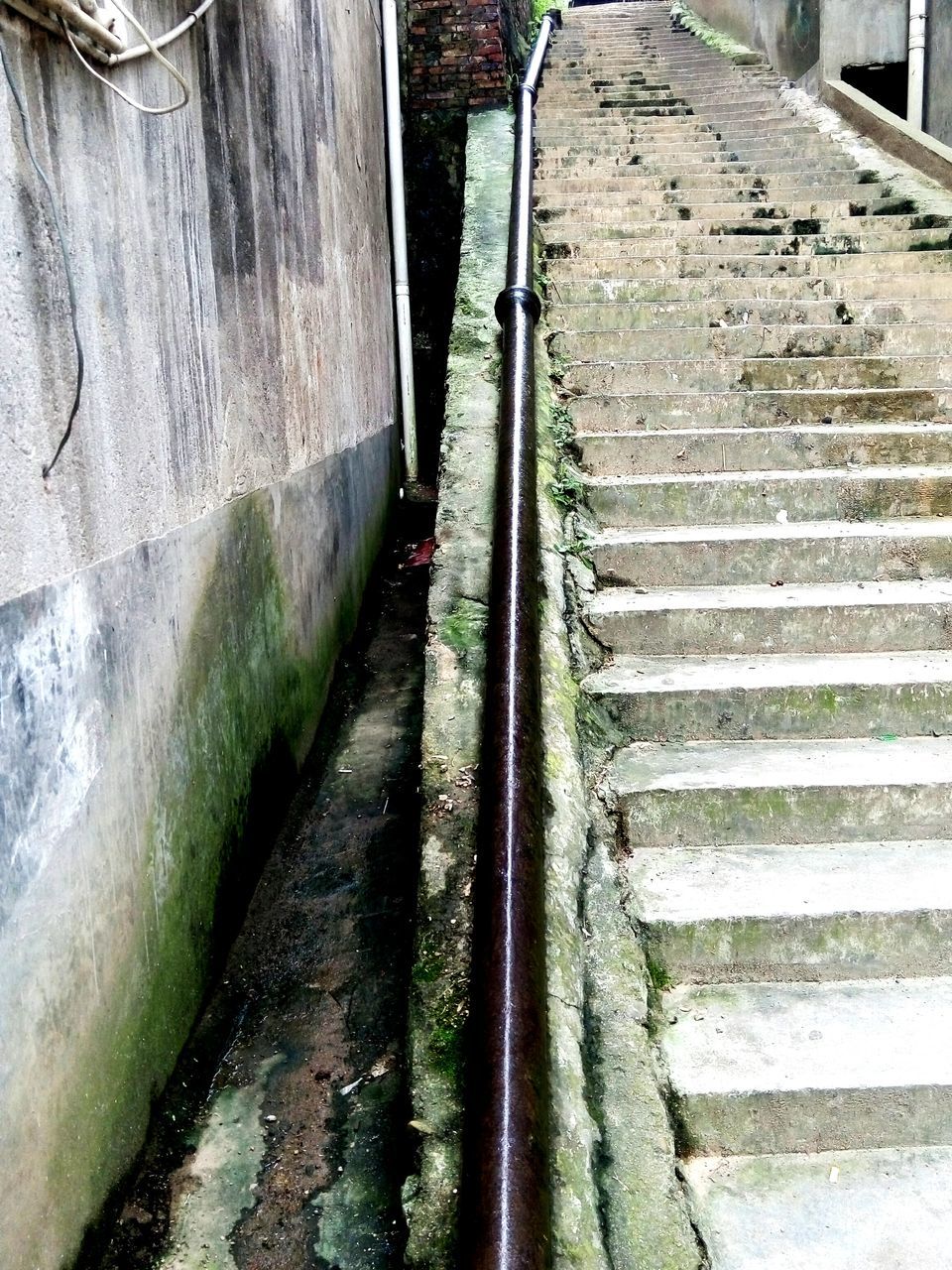 transportation, the way forward, built structure, building exterior, architecture, wall - building feature, diminishing perspective, day, outdoors, steps, mode of transport, old, street, weathered, damaged, vanishing point, no people, abandoned, high angle view, narrow