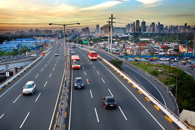 High angle view of cars moving on road in city against sky