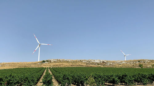 Windmill on field against clear sky