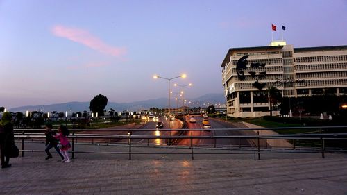 People in city against sky at night