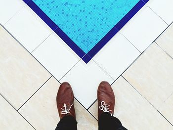 Low section of man standing on tiled floor