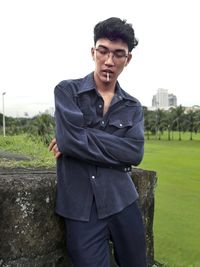 Portrait of young man standing against sky