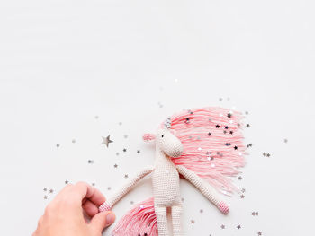 Cute fairy unicorn with pink mane made of threads. handmade toy. trendy creature, symbol of magic.