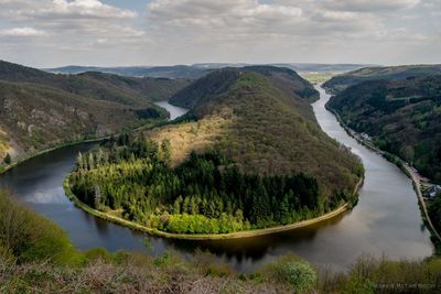 High angle view of river amidst mountains against sky