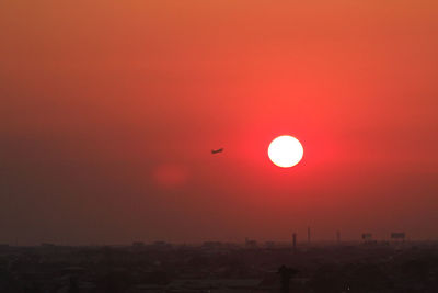 Silhouette of bird flying against sky during sunset