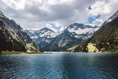 Scenic view of lake by mountains against sky