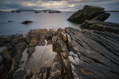 Rock formations by sea against sky