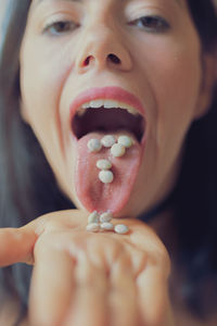 Close-up portrait of woman taking medicines at home