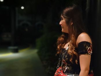 Side view of young woman looking at camera