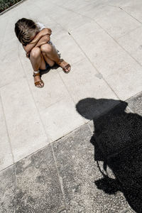 High angle view of woman with dog on floor in city