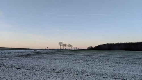 Scenic view of snow field against sky during sunset