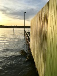 Pier over sea against sky during sunset