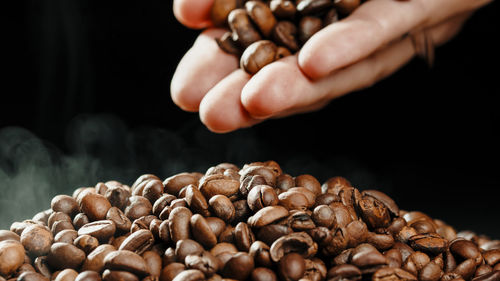 Hand touching roasted coffee beans