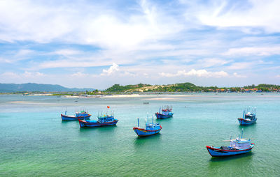 Boats moored in sea against sky