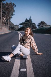 Young woman sitting on road