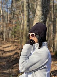 Woman wearing sunglasses standing in forest