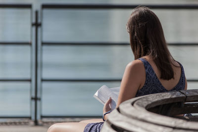 Rear view of woman sitting outdoors