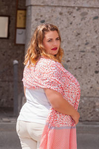 Portrait of beautiful woman standing against wall