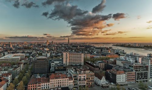 Aerial view of cityscape against cloudy sky