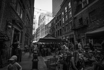 People on street amidst buildings in city