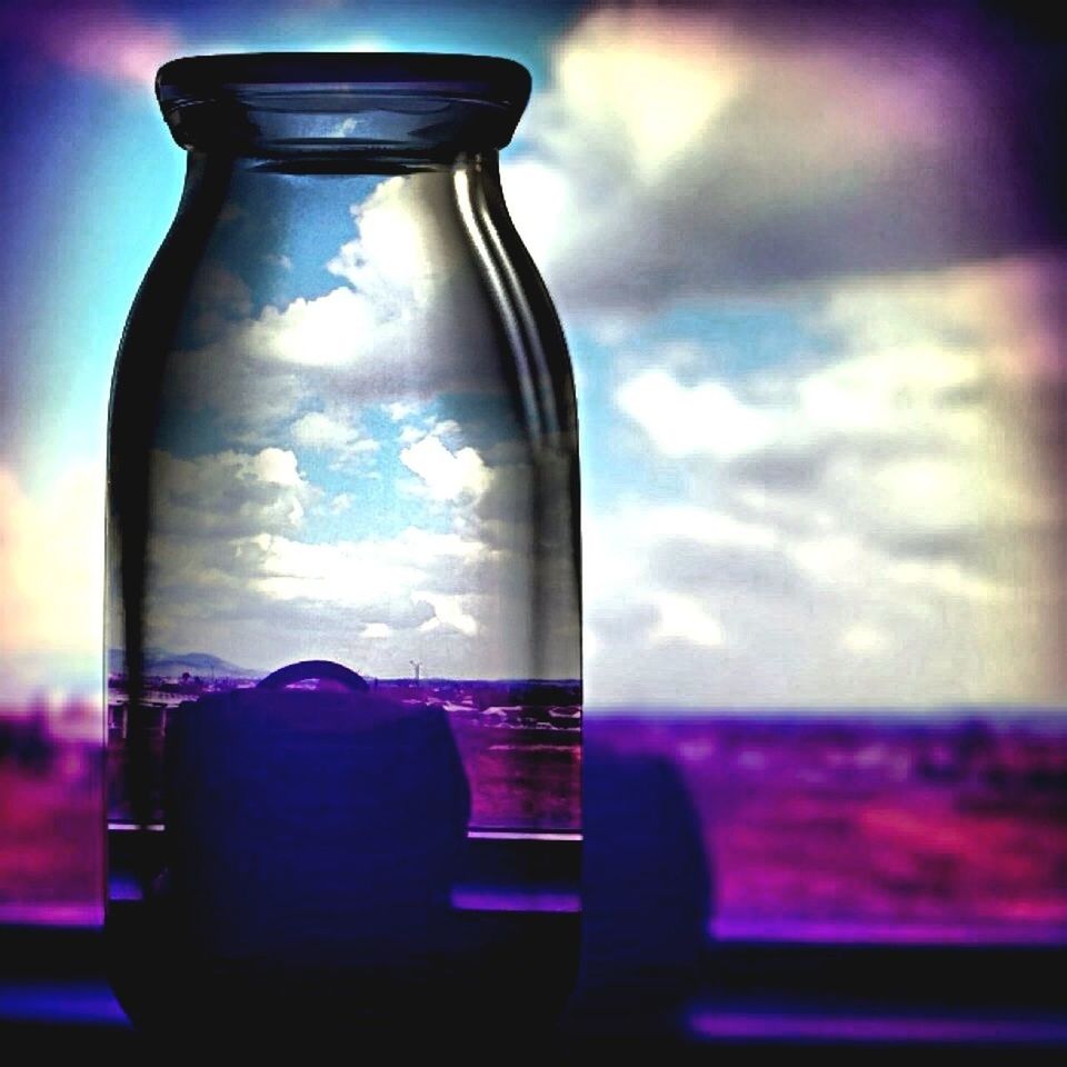 indoors, glass - material, transparent, close-up, focus on foreground, glass, window, still life, sky, home interior, blue, table, no people, selective focus, drinking glass, reflection, day, drink, bottle, vase