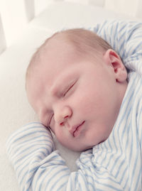 Cute baby sleeping on bed at home