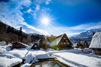 Snow covered houses and buildings against sky