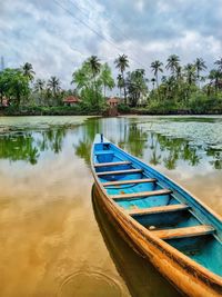 Boat moored in lake against sky