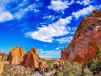 Low angle view of rocks against cloudy sky