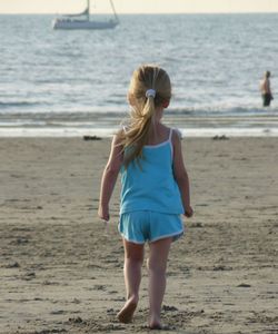 Rear view of woman walking on beach