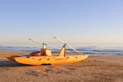 Ship on beach against clear sky